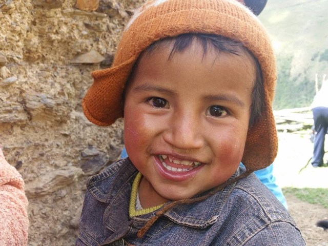 ...a little face peeking from behind an adobe wall called my attention. How could it not with those red little cheeks, round head and huge smile! 